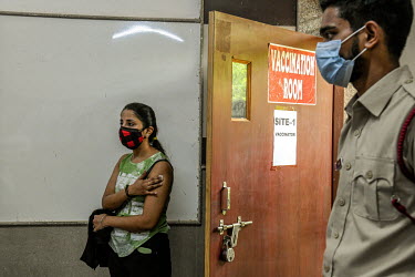 A young woman waits outsdie the vaccination room after receiving her first dose of a Covid 19 vaccine at a government school in Delhi. This is part of phase 3 of the vaccination program In India, whic...