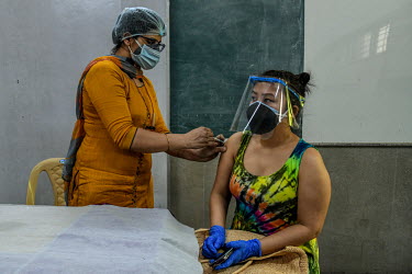A young woman receives her first dose of a Covid 19 vaccine at a government school in Delhi. This is part of phase 3 of the vaccination program In India, which aims to inoculate 18-44 year olds. In De...