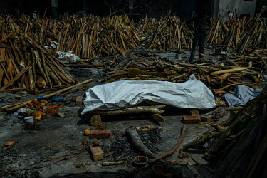 The body of someone who died from Covid 19 lies on a platform surrounded by funeral pyre before a mass cremation at a crematorium in New Delhi.