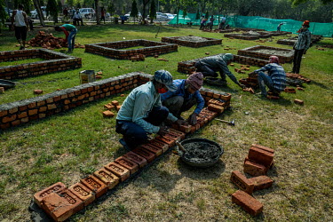 Workers build new brick platforms to cremate bodies inside a crematorium, amid the spread of the coronavirus disease in New Delhi, India