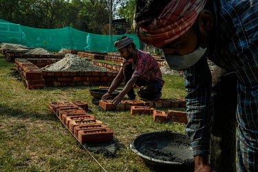 Workers build new brick platforms to cremate bodies inside a crematorium, amid the spread of the coronavirus disease in New Delhi, India