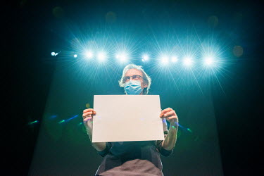Michel Hänggeli of Theatre Forum Meyrin holding up a white card to check the light balance for video. The team is preparing for an experimental performance based on dancer Lucie Eidenbenz's project J...