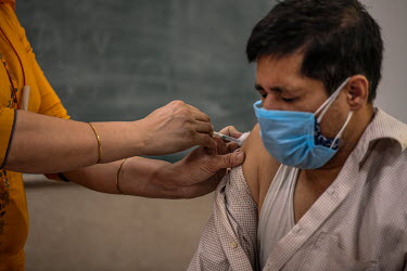 A man receives his first dose of a Covid 19 vaccine at a government school in Delhi. This is part of phase 3 of the vaccination program In India, which aims to inoculate 18-44 year olds. In Delhi ther...