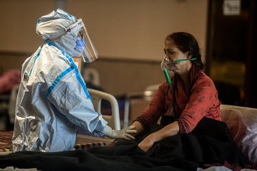 A health workers in personal protective equipment cares for an older woman in a temporary medical facility set up during the Covid 19 pandemic in Delhi opposite the Lok Nayak Jai Prakash Narayan hospi...