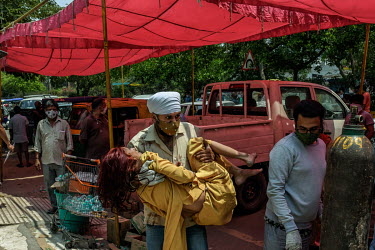 An older woman with very low oxygen saturation is carried to receive free oxygen support at a gurdwara, a place of assembly and worship for Sikhs, amidst the spread of the coronavirus disease, in Delh...