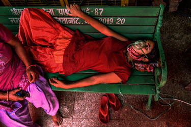 A young woman suffering from breathing problems because of low oxygen saturation lies on a bench while she receives free oxygen support at a gurdwara, a place of assembly and worship for Sikhs, amidst...