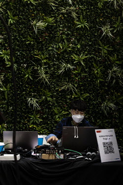 A technician at work in front of a wall of foliage at the Korea Pavilion within the Delegates' pavilion zone in the COP26 summit, at the Scottish Exhibition Centre in Glasgow, Scotland.