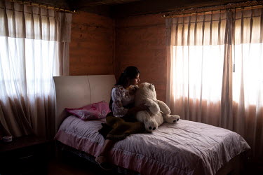 Sharik Nayeli Guatemal, a 15 year old Karanki girl, poses for a portrait with a huge teddy bear in her room. Being an indigenous woman is something she is proud of, and she does not want to abandon he...