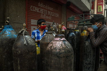 People with empty oxygen cyclinders queue at a refilling center in Delhi during the coronavirus pandemic.