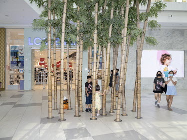 Children play among bamboo poles inside the Mega Silk Way shopping mall.