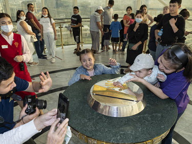 Visitors wait in line to touch the golden cast of the hand of former President Nursultan Nazarbayev in the iconic Bayterek Tower. Those who place their hand in the imprint can make a wish. The develop...