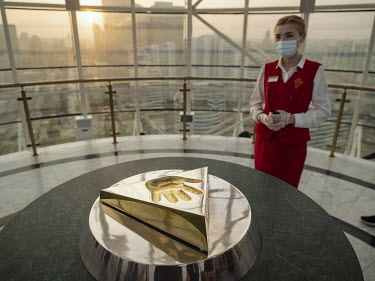 An attendant stands next to the golden cast of the hand of former President Nursultan Nazarbayev in the iconic Bayterek Tower. Those who place their hand in the imprint can make a wish. The developmen...