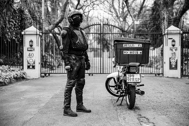 Pardon 'Robocop' Sibanda poses next to his delivery bike which has 'Jesus is my Boss' written on the box. He works hard during the week but on Sundays he serves as a lay minister in a charismatic chur...