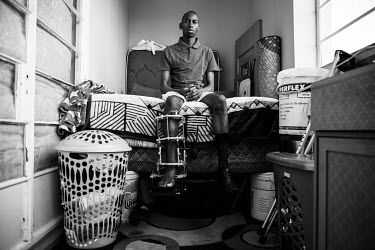 Sikhumbuzo Gwebu sits on his bed with a frame holding his broken leg in place. He was badly injured in a crash and was lucky not to lose his leg. He doesn't get paid when he doesn't work and now he wi...