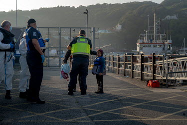 A young girl picked up in the English Channel aboard a boat is brought ashore by Border Force at Dover.