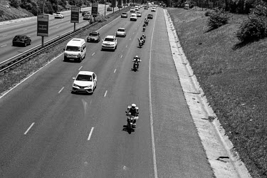 A convoy of food delivery riders makes its way along the Johannesburg motorway to attend the wedding of a colleague. Riders decorated their bikes and wore plastic garlands to celebrate their colleague...