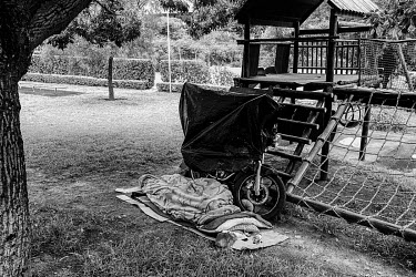 A food delivery rider sleeps out in the open alongside his bike.