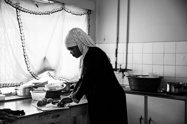Londi preparing food for her family at home. She works as a food delivery driver. Many women drivers prefer to use a car rather than a bike for work as they feel less exposed in a car.