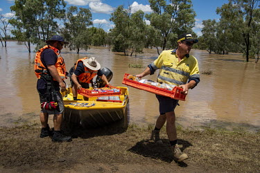 State Emergency Service (SES) volunteers and locals help to transport food, supplies and people stuck on the other side of the flooded town of Wee Waa.