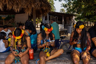 Irantxe Manoki youths use their mobile phones in an indigenous village in the Irantxe indigenous lands.