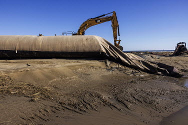 Machines work on the reconstruction of a protection dike, nicknamed 'burrito', on the Grand Isle beach, Louisiana coast, after the passage of Hurricane Ida.