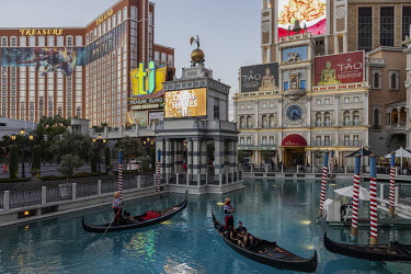 Tourists ride a gondola across an artificial lake imitating the Italian city of Venice at The Venetian hotel in Las Vegas.