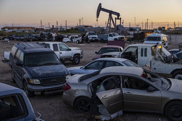 Oil extraction well next to a junkyard near the city of Odessa, Texas. This region of Texas, called the Permian Basin, is responsible for around a third of all oil production in the United States.