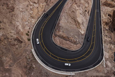 Cars drive along the road leading to the Hoover Dam, located between the states of Nevada and Arizona on the Colorado River. Lake Mead is the largest artificial reservoir in the United States and is a...