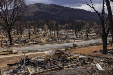 A man runs down a street in the historic Northern California town of Greenville, which was destroyed by a wildfire. The town was devastated by the flames of the Dixie Fire, the largest forest fire in...