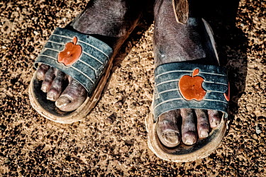 A farmer wears sandals with the Apple and Nike logos.