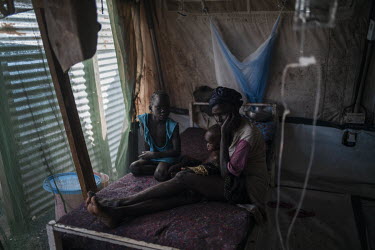 A mother and her children sit on a bed in a Medecins sans Frontieres (MSF) hospital at a Protection of Civilians (POC) camp. 'We are from Jazeera village and we all fled the flooding in October. Nyako...
