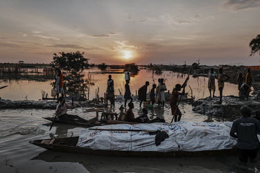 A busy port has sprung up where canoes across the flooded plain. People head through the flood searching for wood to dry to make fires or to go fishing. It is also where people arrive every day from f...