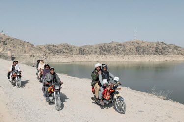 Taliban ride motorcycles along the banks of the Arghana Dam reservoir, near Kandahar, where water level has dropped significantly over the past two years.