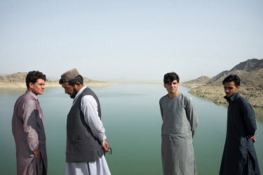 Visitors walk along the banks of the Arghana Dam reservoir, near Kandahar, where water level has dropped significantly over the past two years.
