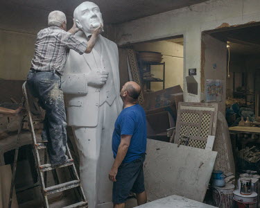 A sculptor adds the head to a statue of Mustafa Kemal Ataturk, made for a school playground, in a studio in KagÄ�thane.