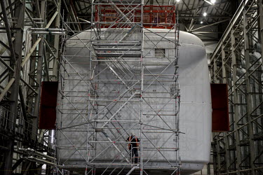 An engineer checks the scaffolding against a vast wind-turbine blade testing machine in a test hall Catapult Innovation and Research Centre for Offshore Renewable Energy. The former coal mining area o...