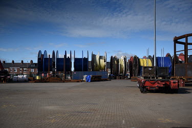 A row of houses is dwarfed by reels of cable which are laid at sea for offshore energy projects, at the Port of Blyth, which supports multiple businesses in the energy sector. The former coal mining a...