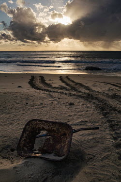 A washed up wheelbarrow and the tracks of green sea turtles that visit the beach to lay during their breeding season. The beaches around Itsamia in the north of the Comoros island of Moheli are a glob...
