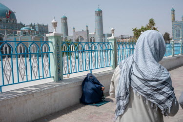 A woman in a burqa begs outside the Great Blue Mosque (Rawze-e-Sharif, Shrine of Hazrat Ali).
