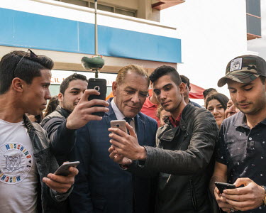 Men ask for selfies with Mustafa Kemal Ataturk lookalike impersonator Goksal Kaya on a street in Izmir.