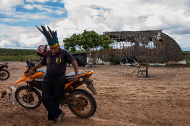 The chief of the Haliti Paresi people, Rivelino Kanezomae, stand with his motorbike in front of a partially constructed hati, a traditional house, in a village in Figueiras Indigenous Land. A few kilo...