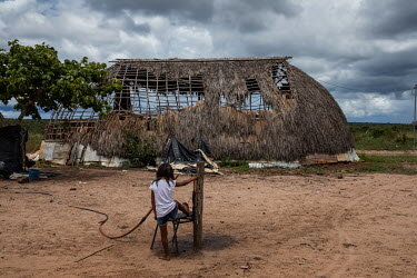 A girl from the Haliti Paresi people washes her feet at a tap in front of a partially constructed hati, a traditional house, in a village in Figueiras Indigenous Land. A few kilometers from the reserv...