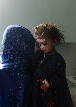 A mother and her malnourished child in a therapeutic feeding unit at the Medecins Sans Frontieres (MSF) Lashkar Gah hospital, where each bed is occupied by two children.