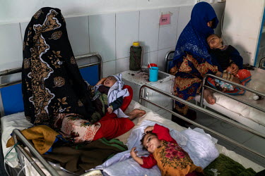 Mothers with their malnourished children in a therapeutic feeding unit at the Medecins Sans Frontieres (MSF) Lashkar Gah hospital, where each bed is occupied by two children.