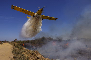A plane drops water over a fire on the banks of the Transpantaneira road, in Mato Grosso.