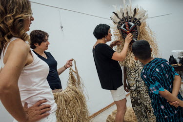 In preparation for the 10th annual Dana Bayram (Calf Festival) held in Izmir, Adel (far right) looks at some generic African costumes designed by a Turkish costume designer (holding the mask).