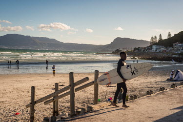Surfers at Cape Town beach with Table Mountain behind.