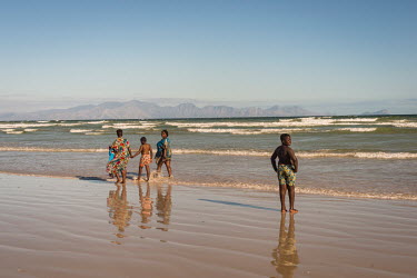 A family play in the waves at Cape Town beach.