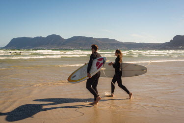 Surfers at Cape Town beach with Table Mountain behind.
