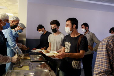 Afghan migrants queue for food at an immigration deportation removal centre for migrants near Van. Hundreds of people are detained here, mostly from Afghanistan, before being processed and granted asy...